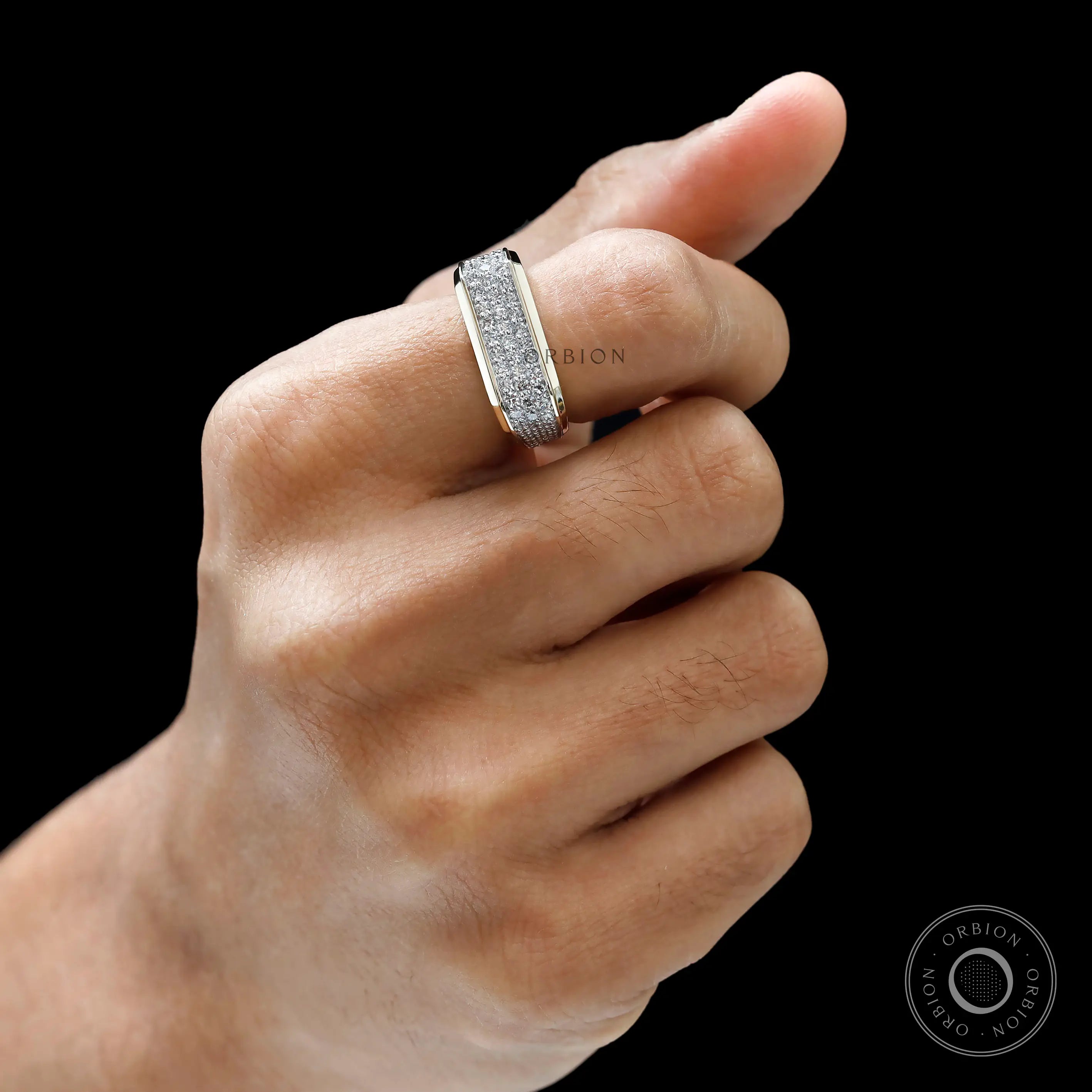 pavé diamond setting on men’s yellow gold ring on finger