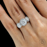 Close up of round center stone with halo and side stones