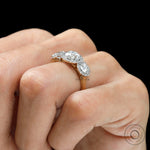 Cathedral shoulder detailing on two tone gold engagement ring on hand