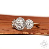 Side profile of cathedral style three stone halo engagement ring