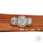 Front view of round three stone moissanite halo engagement ring with cathedral setting