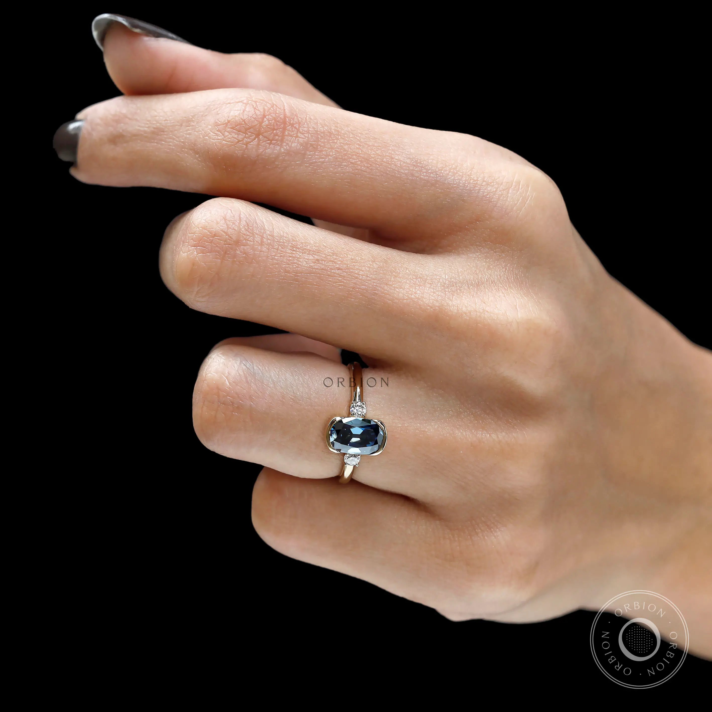 Modern vintage blue moissanite engagement ring worn on hand