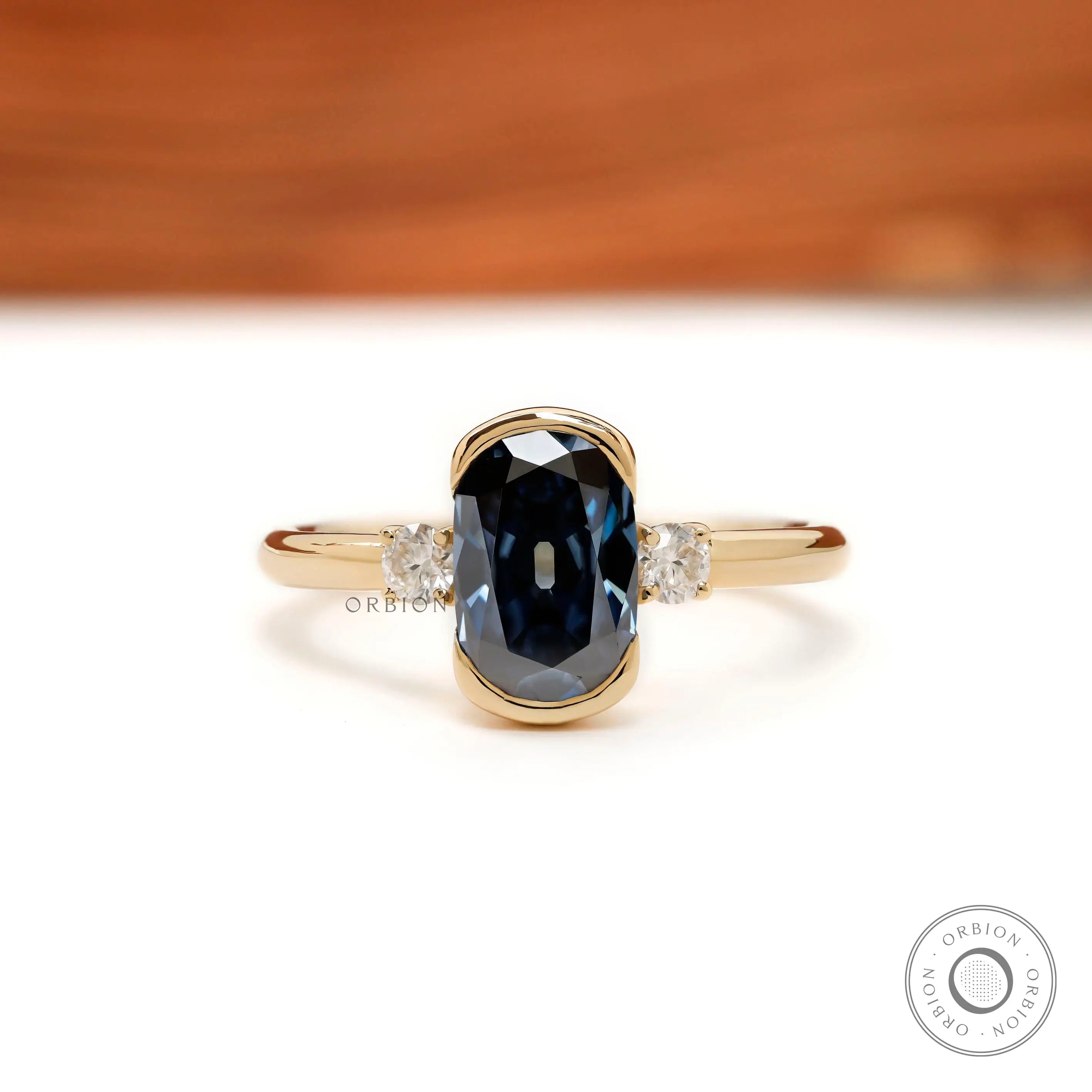 Three stone elongated cushion blue moissanite engagement ring in yellow gold