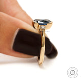 Contemporary three stone engagement ring with deep blue center stone