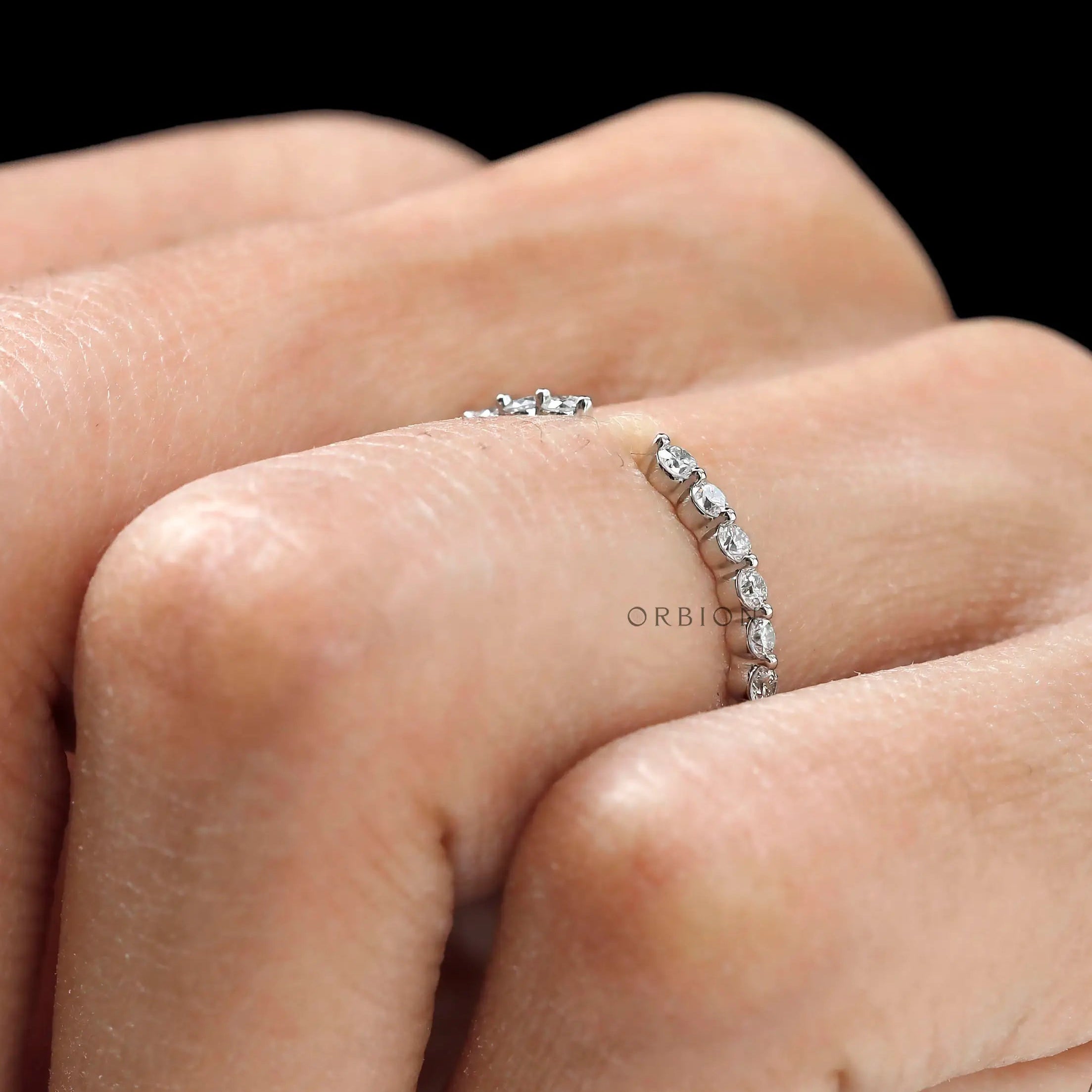 Delicate shared prong round diamond band