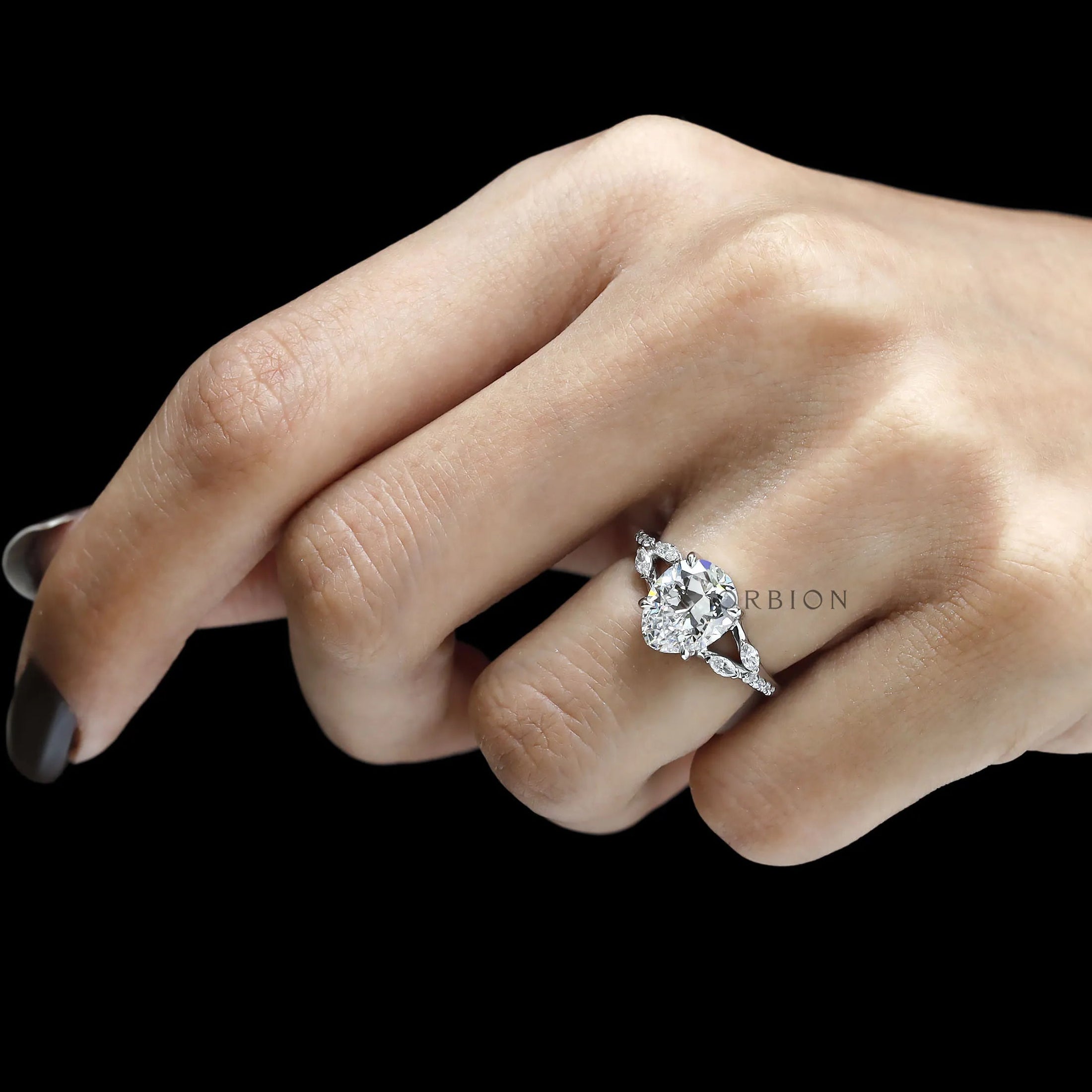 Pear-shaped moissanite platinum engagement ring with split shank and mixed marquise and round stones