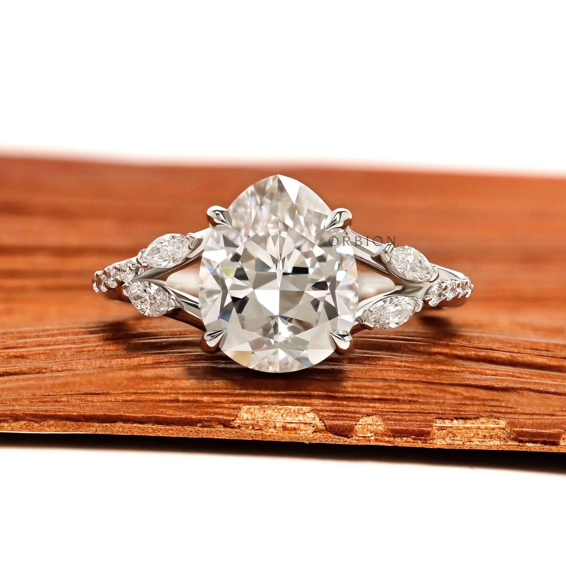 Platinum engagement ring featuring fat pear lab diamond, split shank, marquise and round accent stones