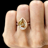 Slitaire pear cut champagne moissanite bezel set cathedral wedding ring close up