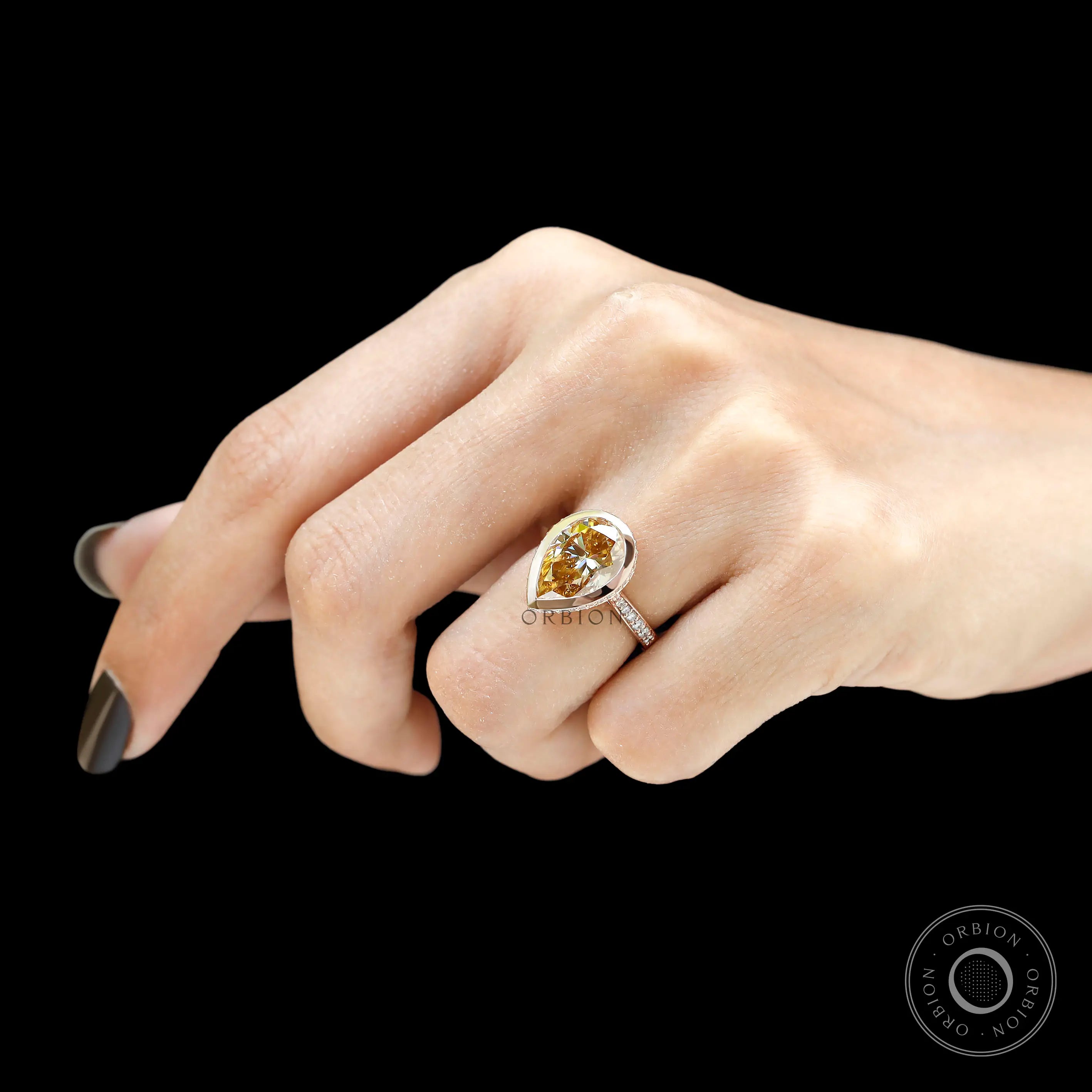 Pear champagne moissanite engagement ring worn on hand