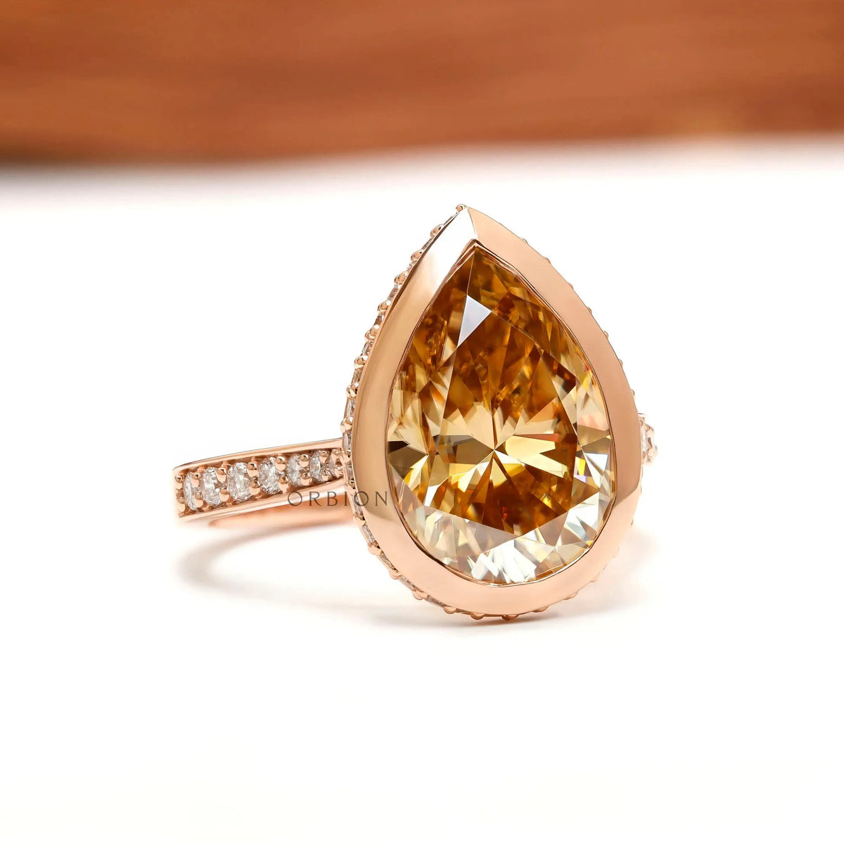 Pear light champagne moissanite pave bezel halo engagement ring in 14k rose gold