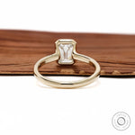 Minimalist emerald cut diamond ring with bezel setting yellow gold