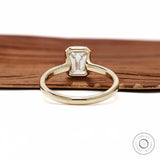 Minimalist emerald cut diamond ring with bezel setting yellow gold