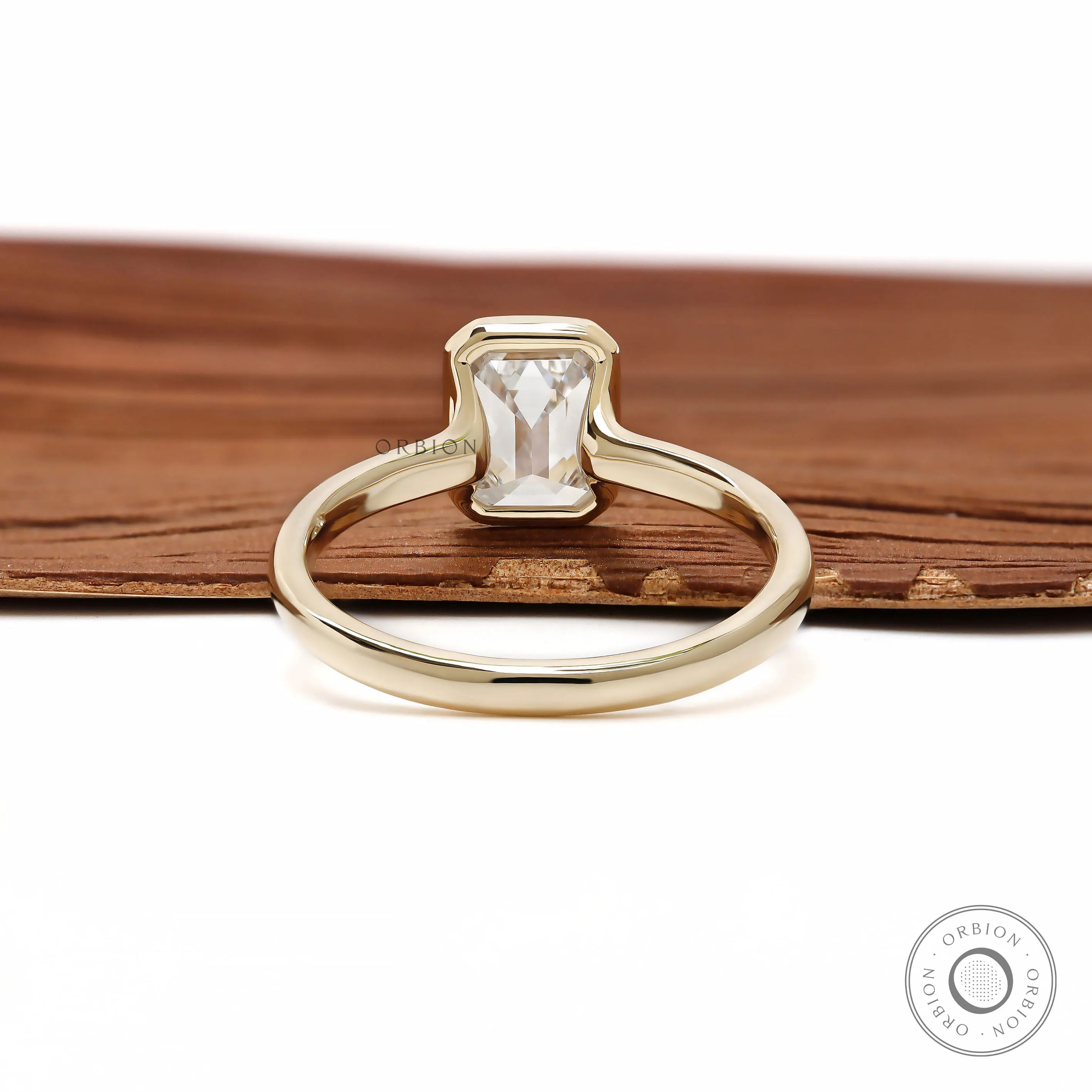 Minimalist emerald cut diamond ring with bezel setting yellow gold