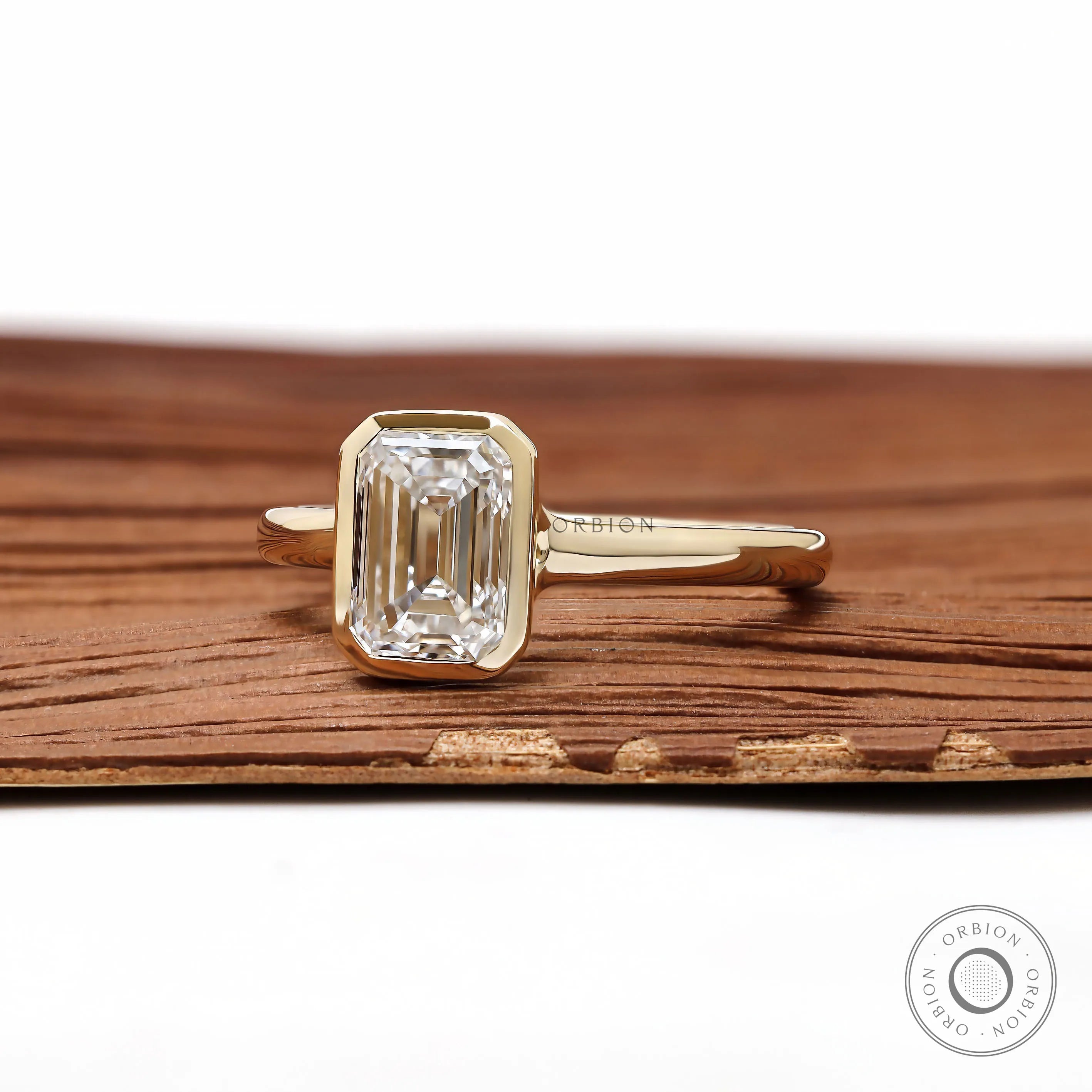 Modern emerald cut lab diamond bezel ring in yellow gold