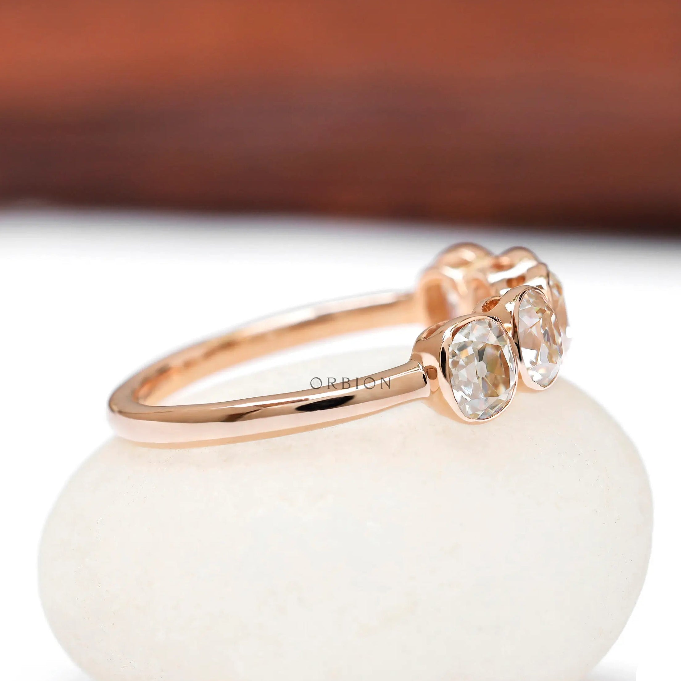 Side view of bezel set five stone rose gold band