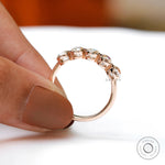 Handheld view of rose gold band with open bezels
