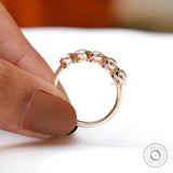 Handheld view of rose gold band with open bezels
