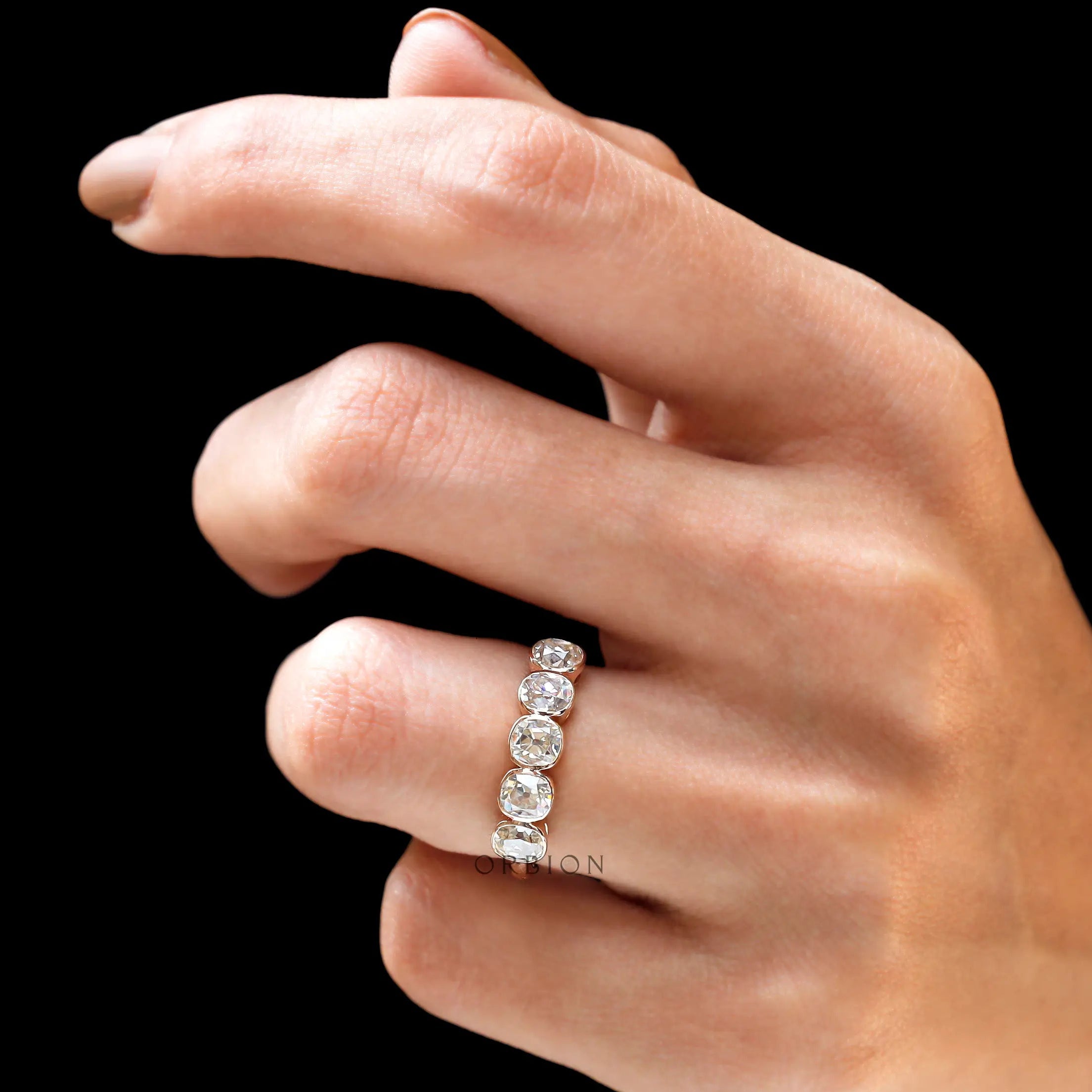 Lifestyle photo of five stone bezel band in rose gold