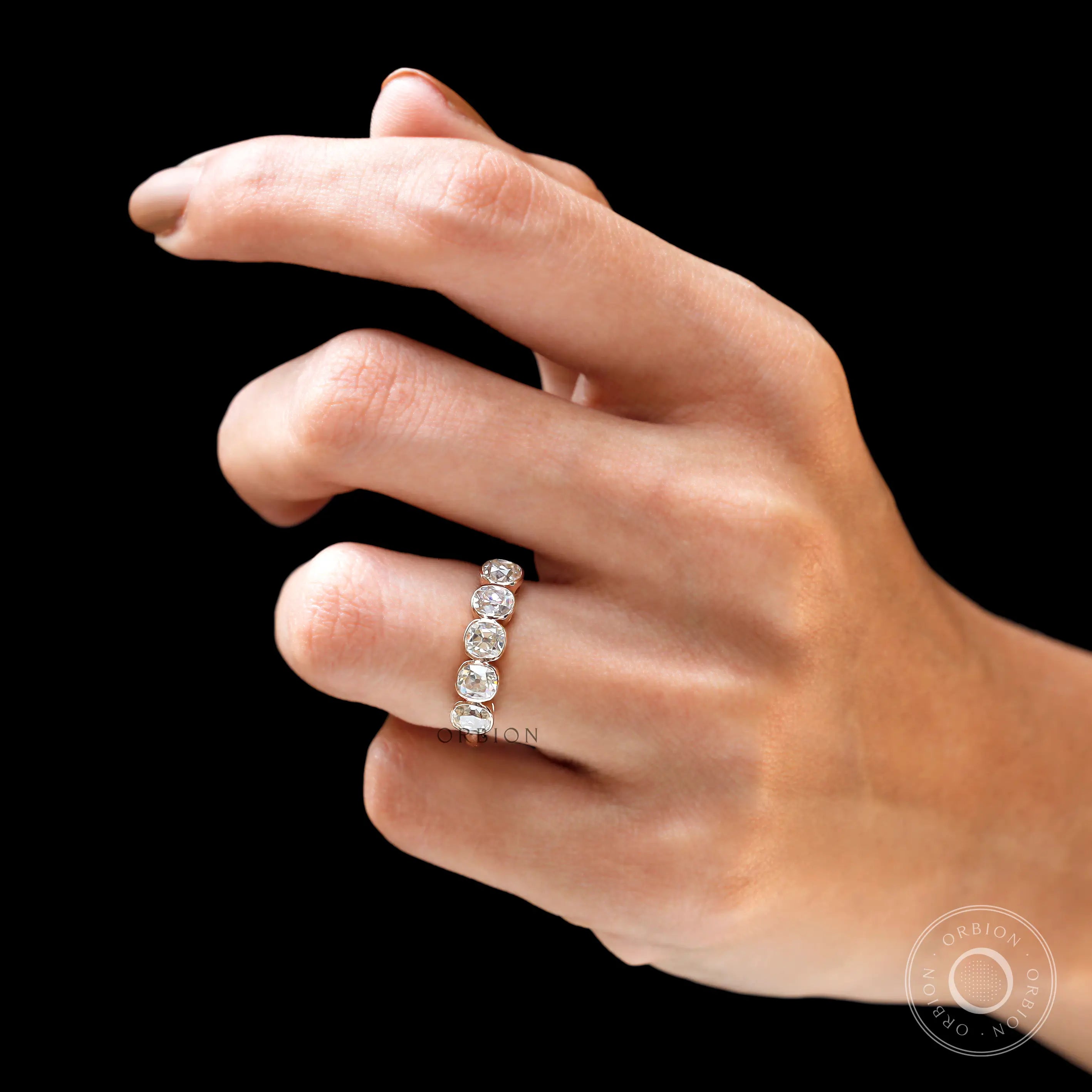 Lifestyle photo of five stone bezel band in rose gold