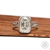 Engraved bezel set elongated cushion moissanite ring thick white gold band