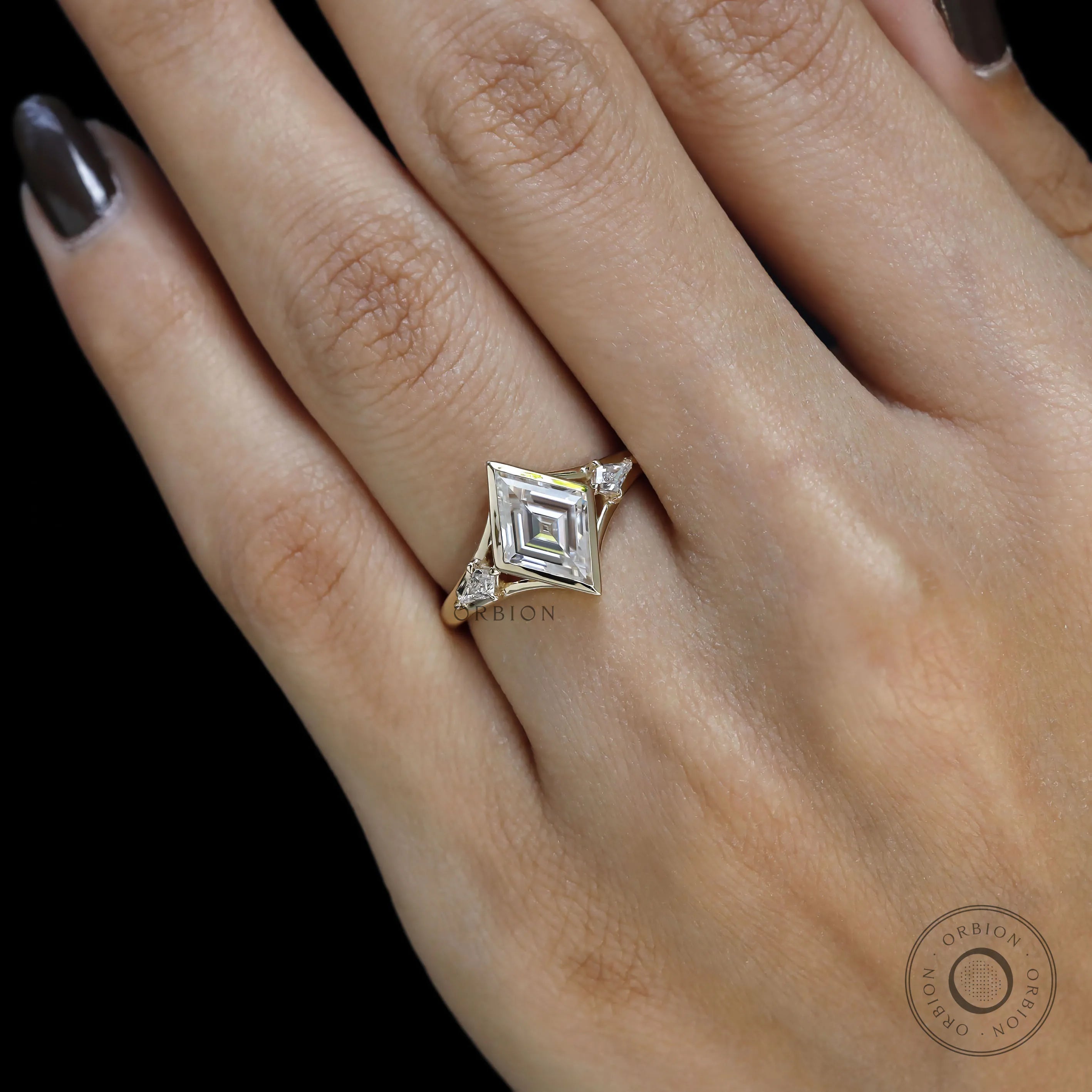 Elegant bezel set lozenge cut moissanite engagement ring with detailed kite accents