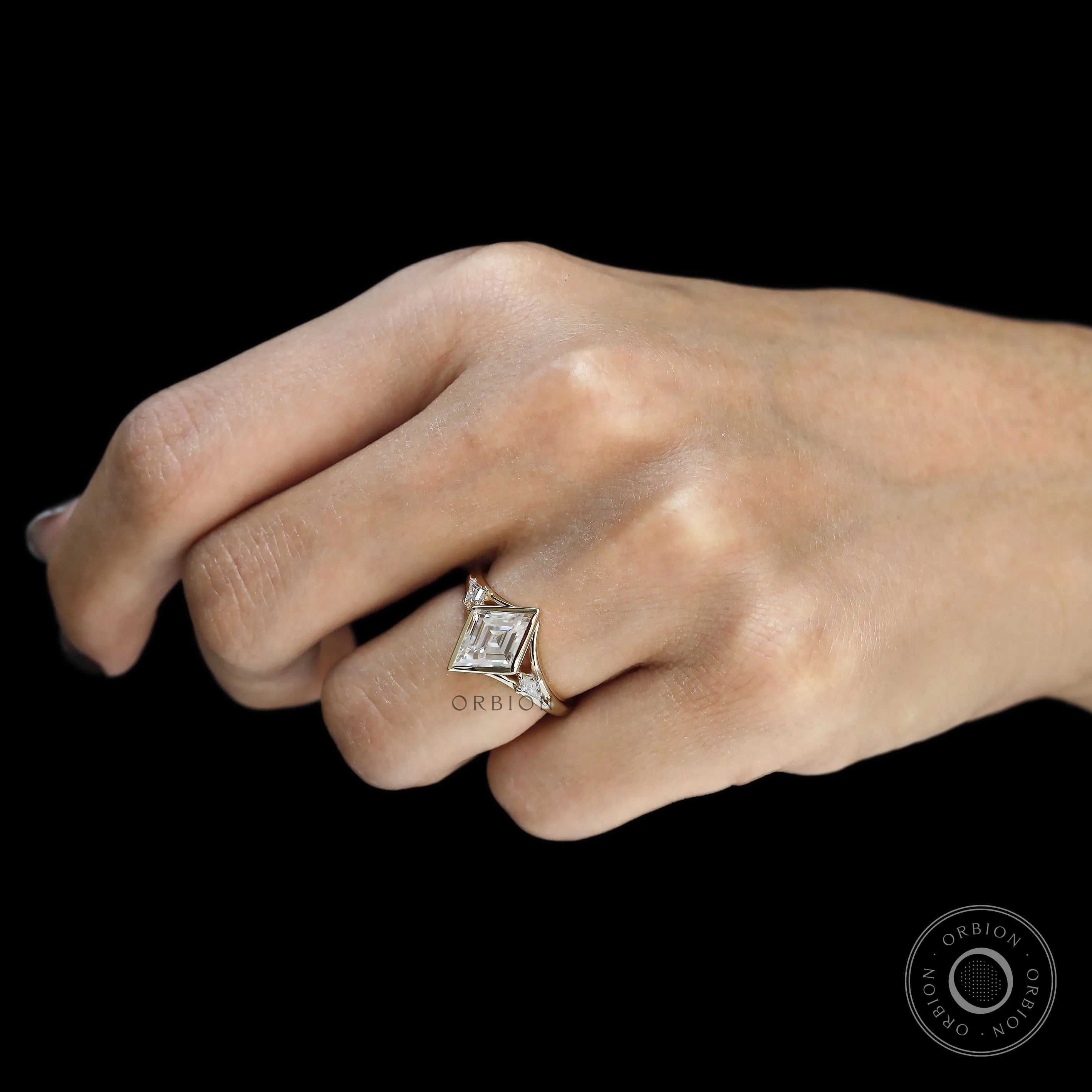 Modern three stone engagement ring with bezel set lozenge cut moissanite in yellow gold