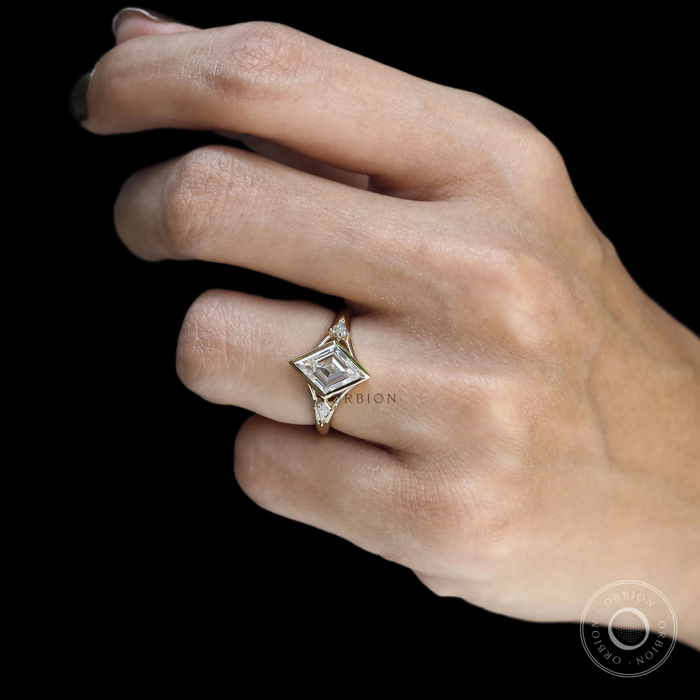 Geometric style moissanite engagement ring with lozenge cut and yellow gold split shank