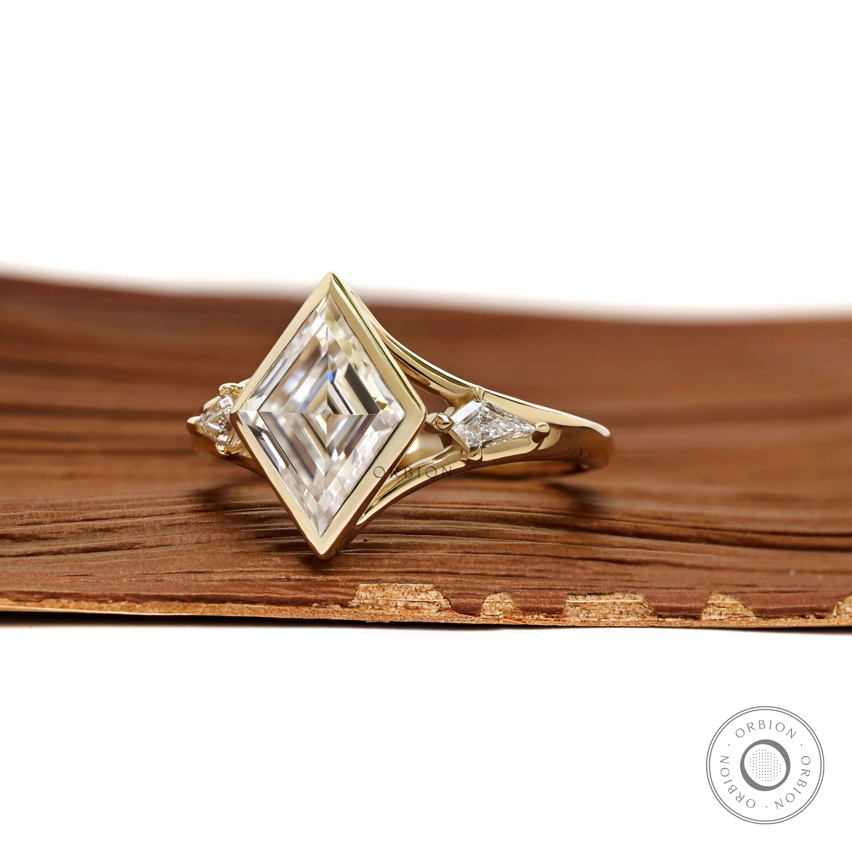 Unique three stone moissanite engagement ring with lozenge cut and yellow gold split shank