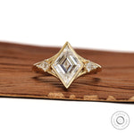 Bezel set lozenge cut moissanite three stone engagement ring with kite accents