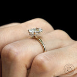 Oval cut moissanite engagement ring with hidden halo, yellow gold setting