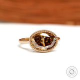Dark champagne oval moissanite ring in East West orientation with rope bezel and tulip setting