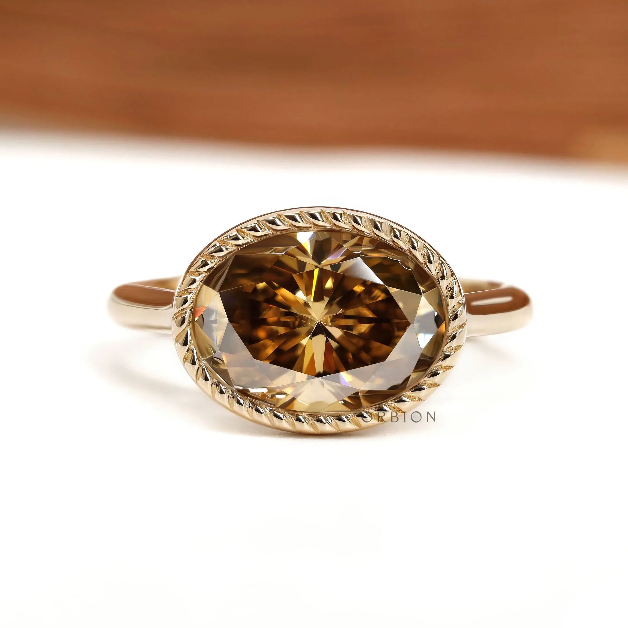 East West oval dark champagne moissanite cocktail ring with tulip setting and rope bezel in 18k yellow gold