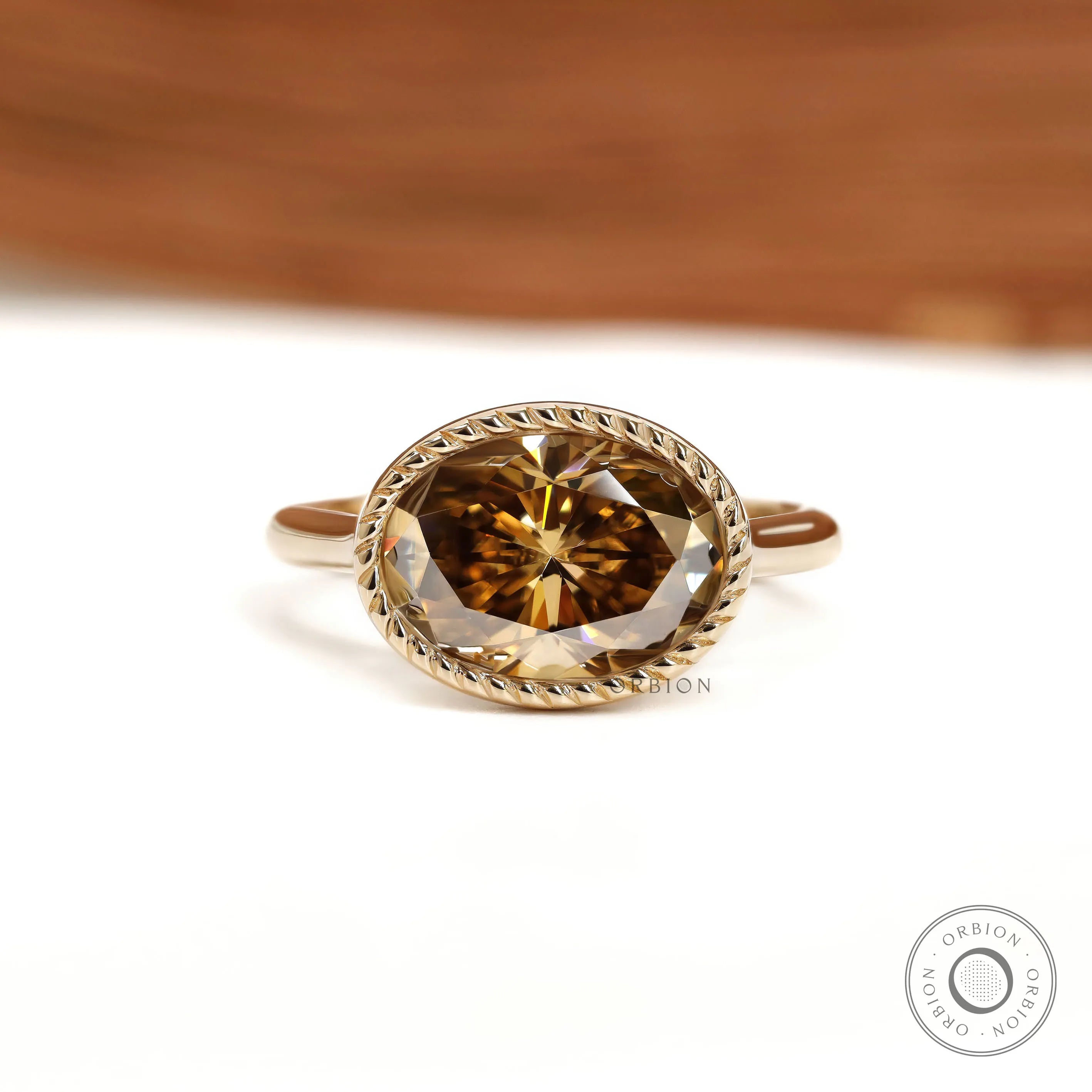 East West oval dark champagne moissanite cocktail ring with tulip setting and rope bezel in 18k yellow gold