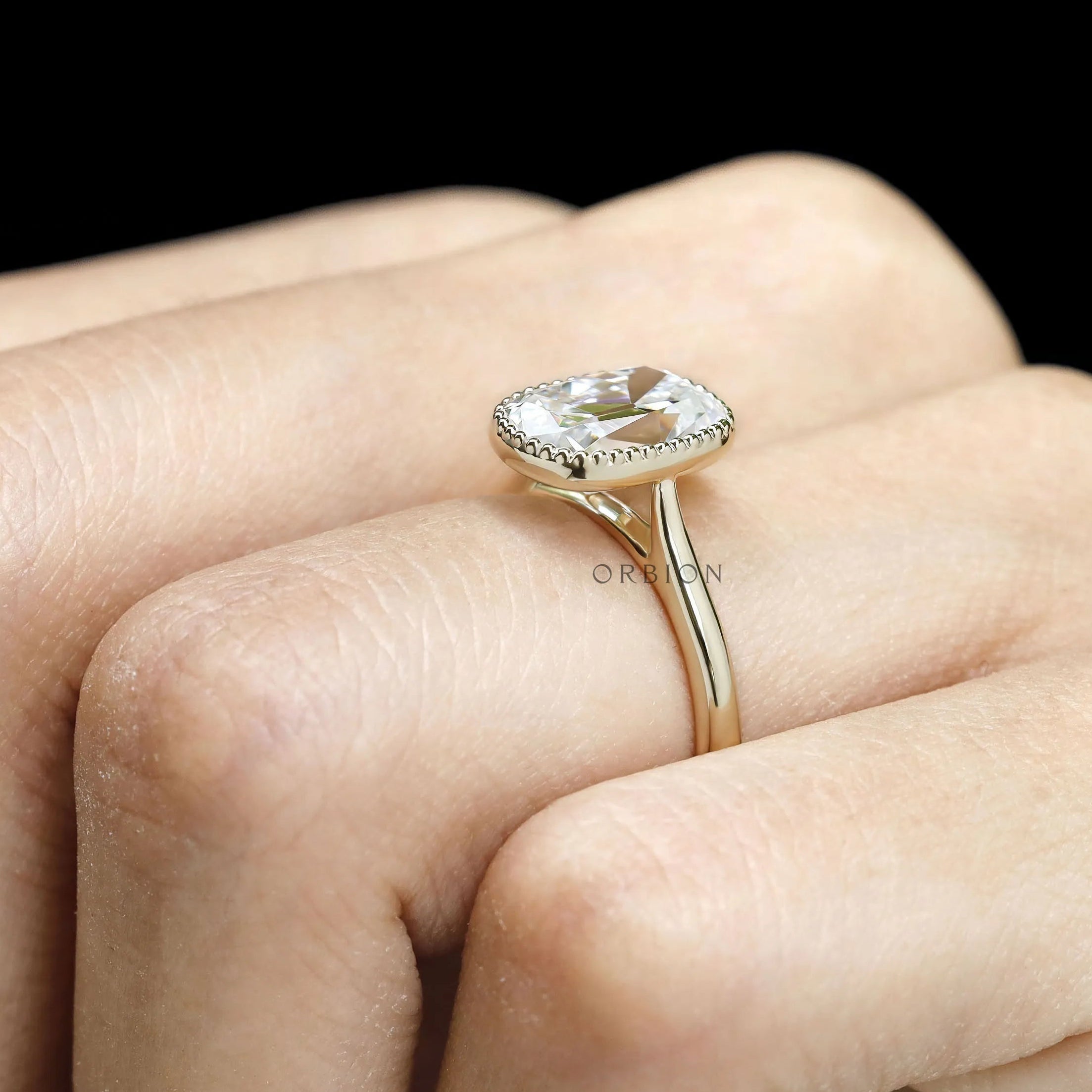 10k yellow gold cathedral engagement ring featuring elongated cushion OMC moissanite with milgrain bezel