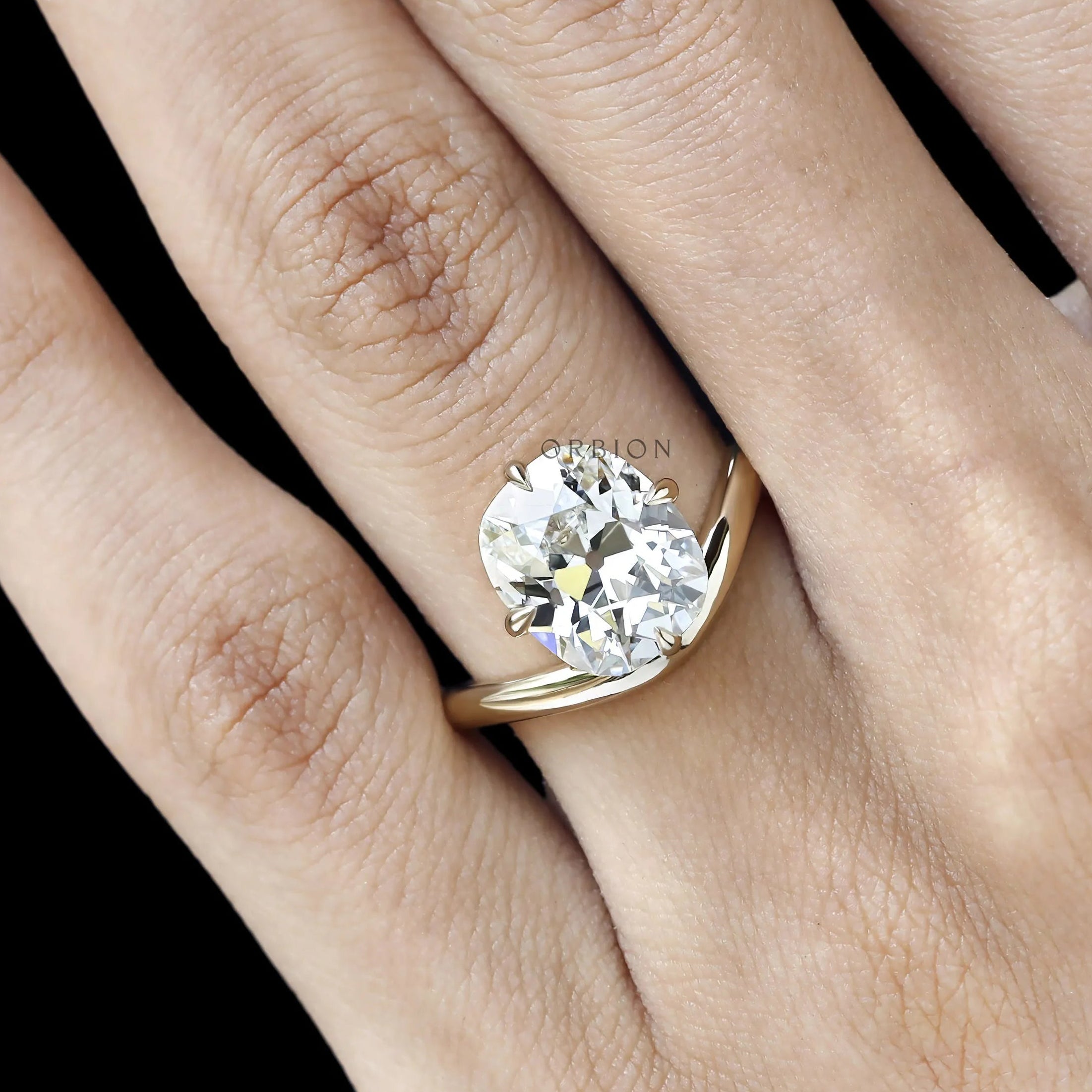 Compass set elongated cushion solitaire ring yellow gold curved band. 