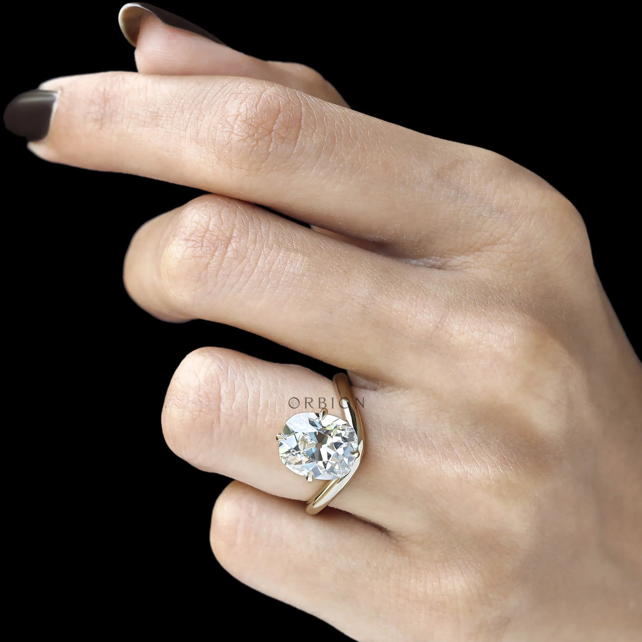 Elongated cushion cut lab diamond ring with curved bypass shank, compass setting, yellow gold