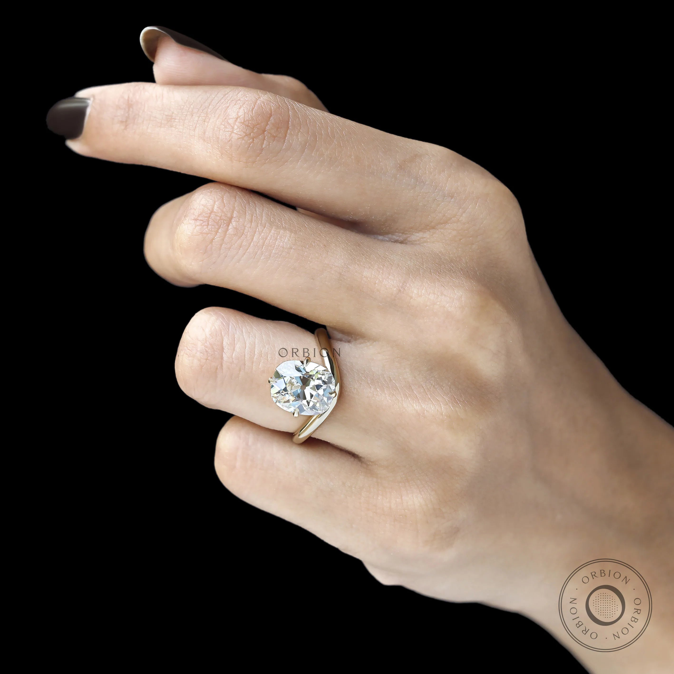 Elongated cushion cut lab diamond ring with curved bypass shank, compass setting, yellow gold