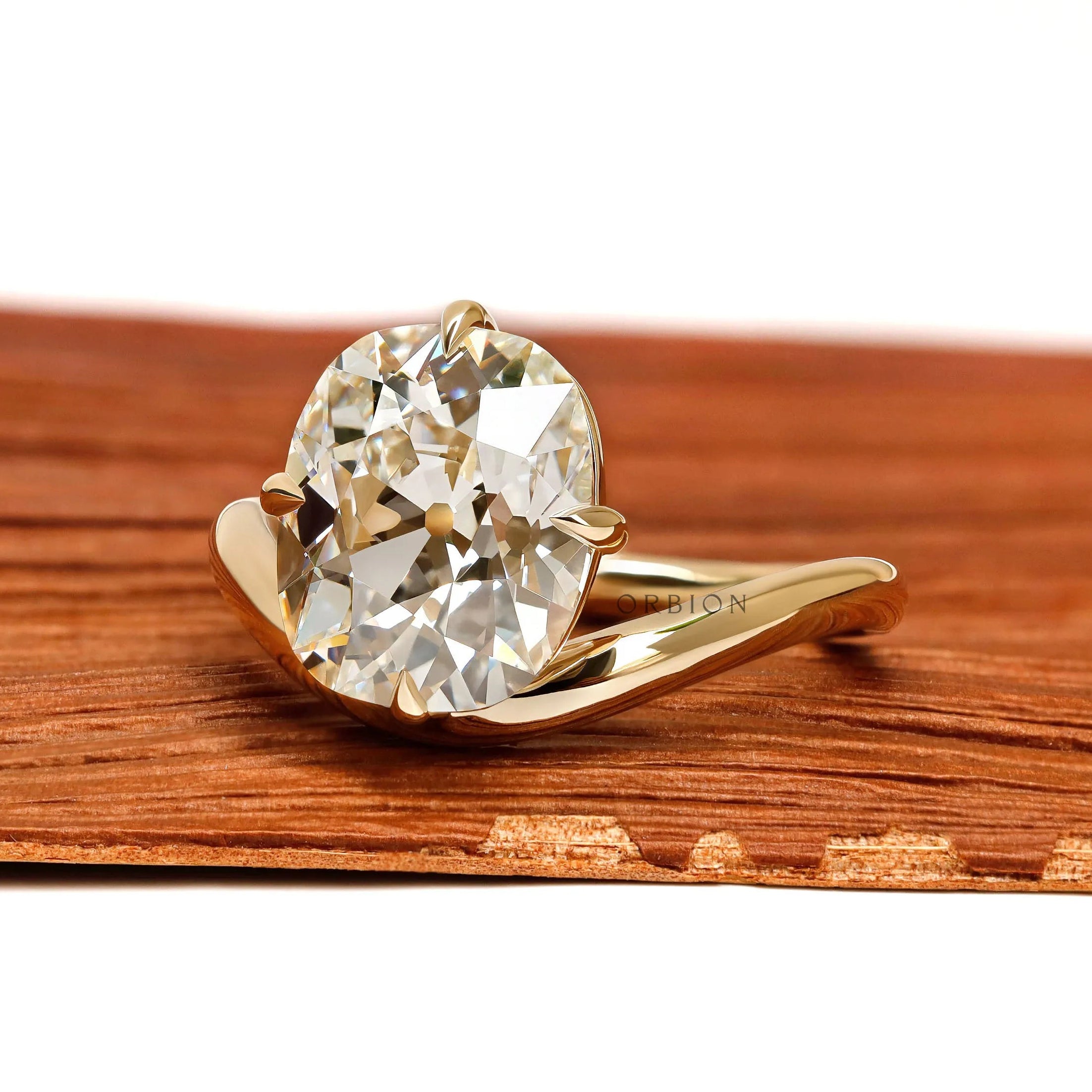 Yellow gold bypass ring featuring curved elongated cushion lab diamond