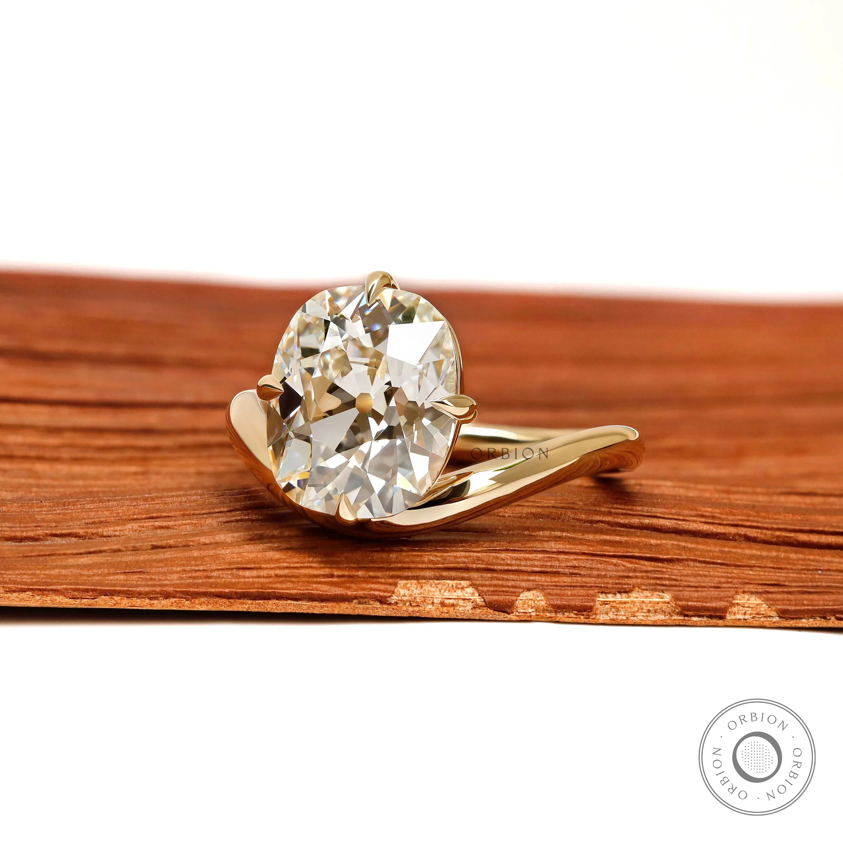 Yellow gold bypass ring featuring curved elongated cushion lab diamond