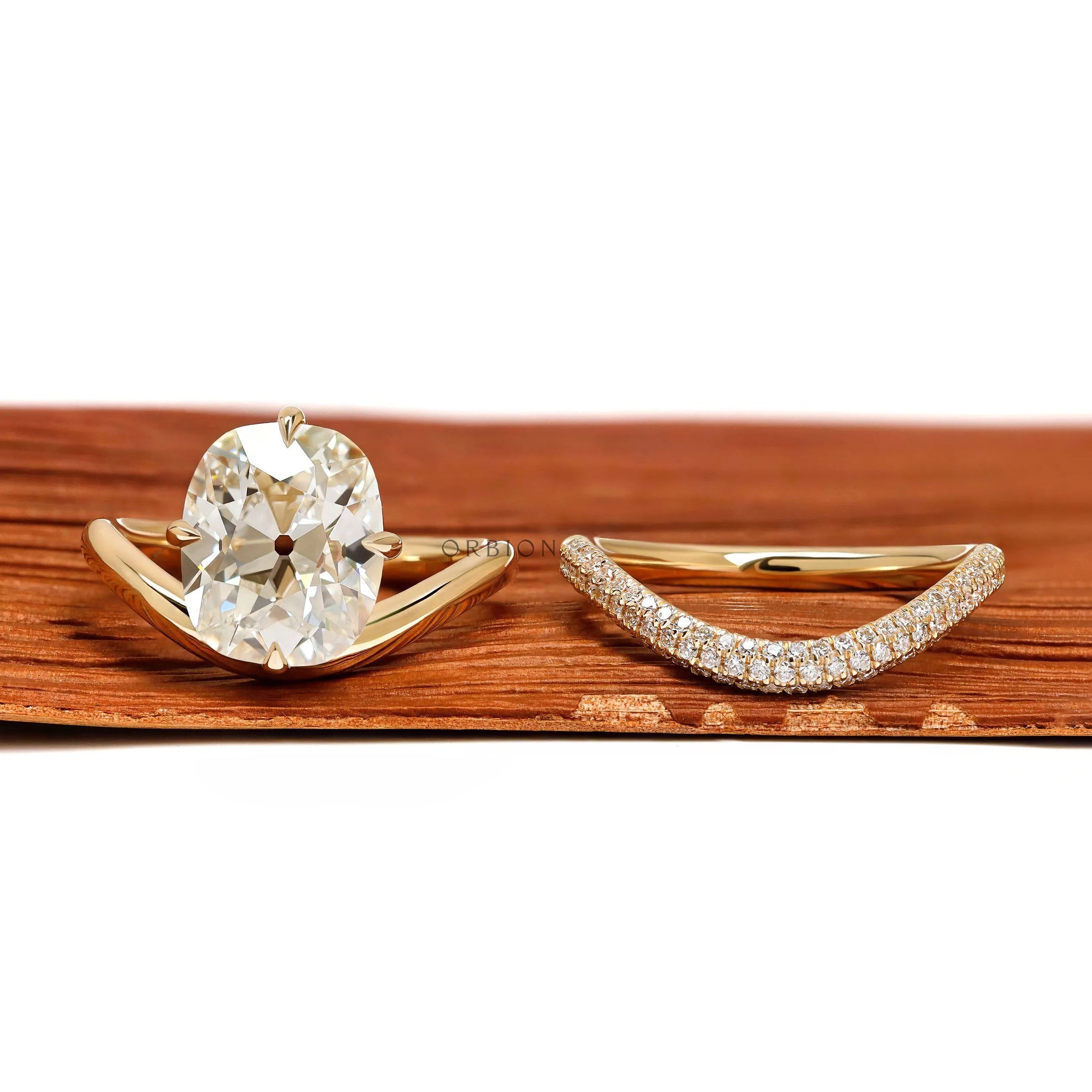 Yellow gold wedding ring set featuring elongated cushion lab diamond with compass setting