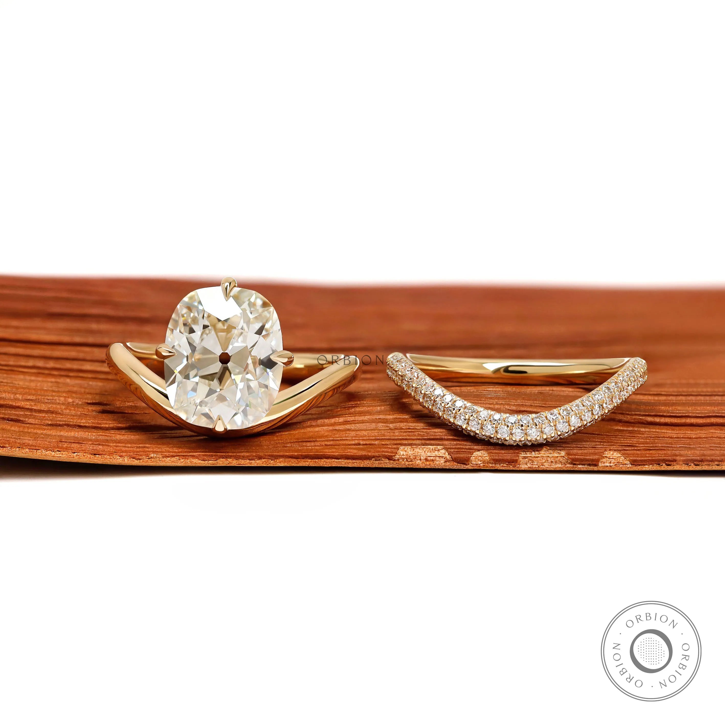 Yellow gold wedding ring set featuring elongated cushion lab diamond with compass setting