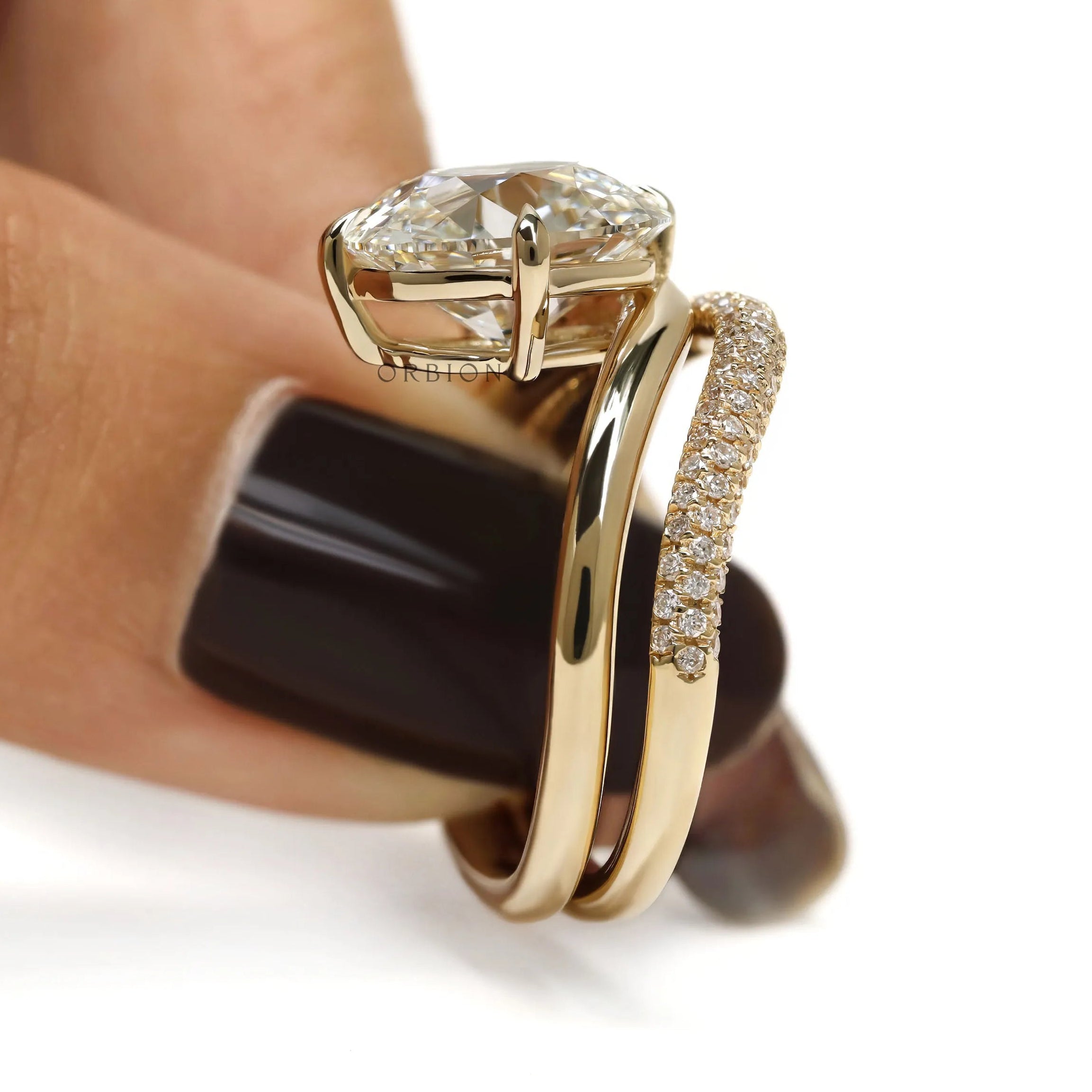 Modern curved engagement ring set in 14k yellow gold, cushion-cut center stone, lab diamond or moissanite