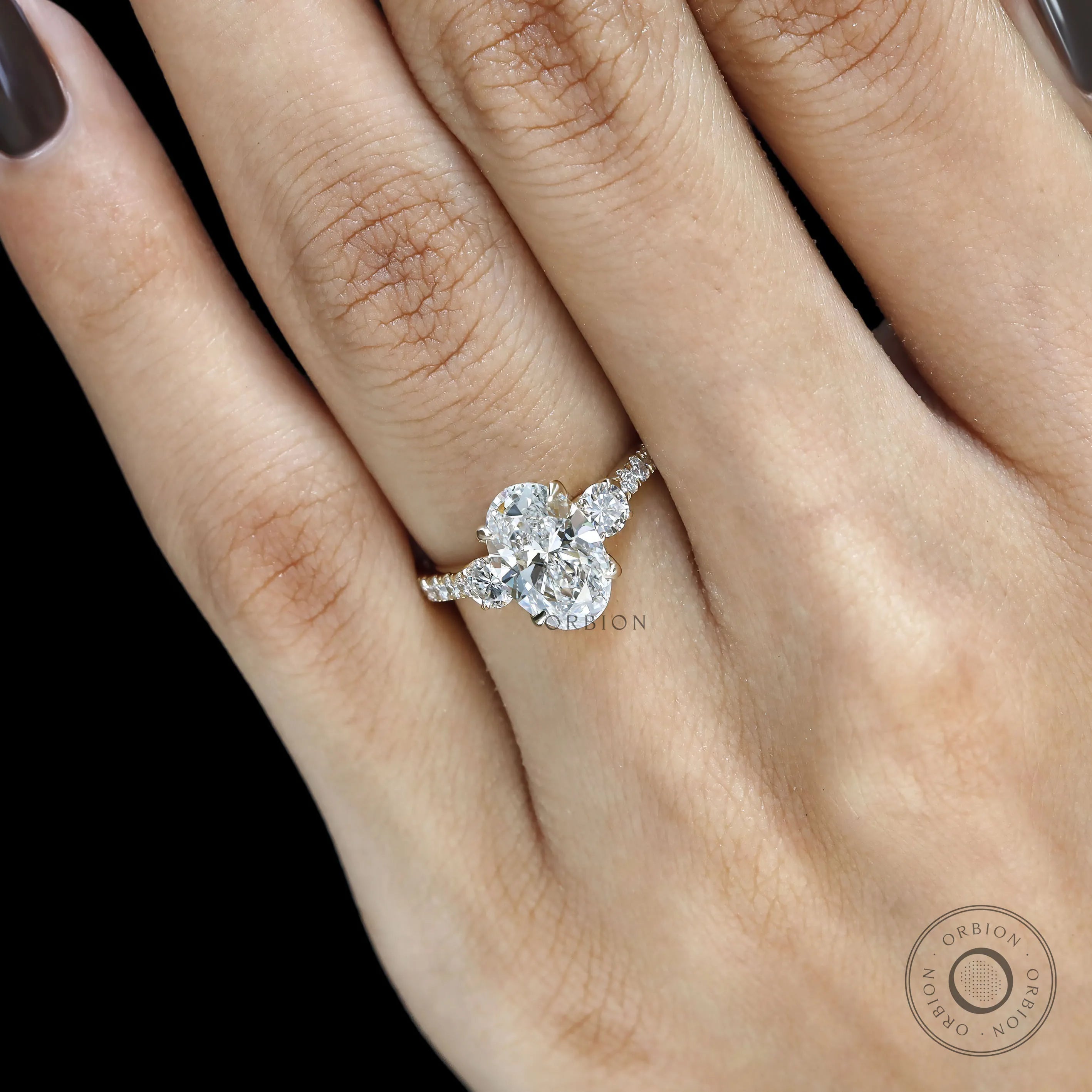 Three stone engagement ring featuring oval moissanite in 14k yellow gold 