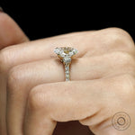 Oval lab grown diamond engagement ring with three stones, yellow gold cathedral band, pave shank