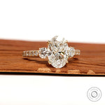 14k yellow gold three stone engagement ring with oval lab grown diamond and pave shank