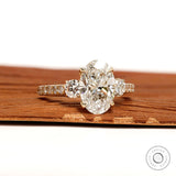 14k yellow gold three stone engagement ring with oval lab grown diamond and pave shank