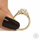 14k yellow gold engagement ring featuring oval lab grown diamond three stone design and pave shank