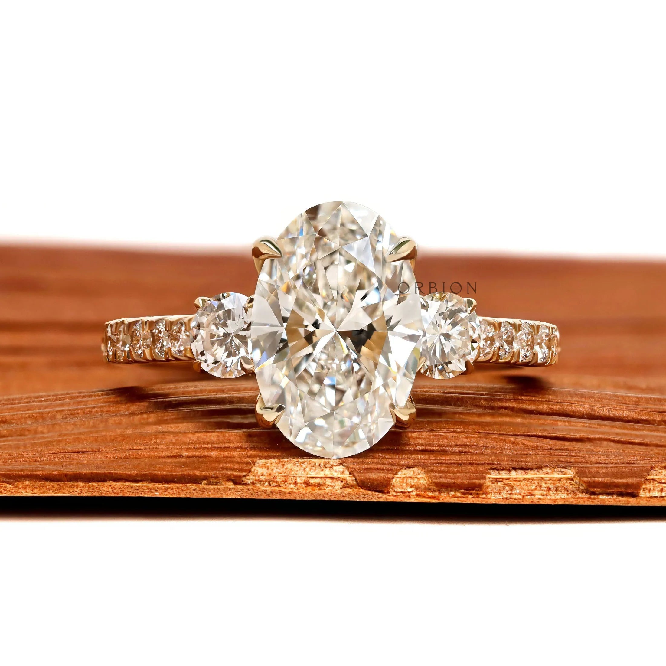 Oval lab grown diamond three stone engagement ring with pave shank in 14k yellow gold, moissanite option