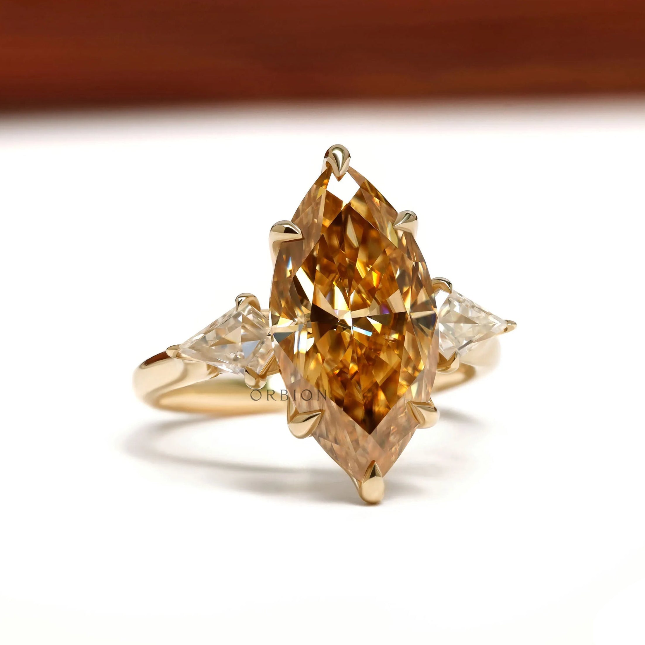 10k yellow gold cathedral ring featuring marquise champagne moissanite, tulip set, and accented bridge