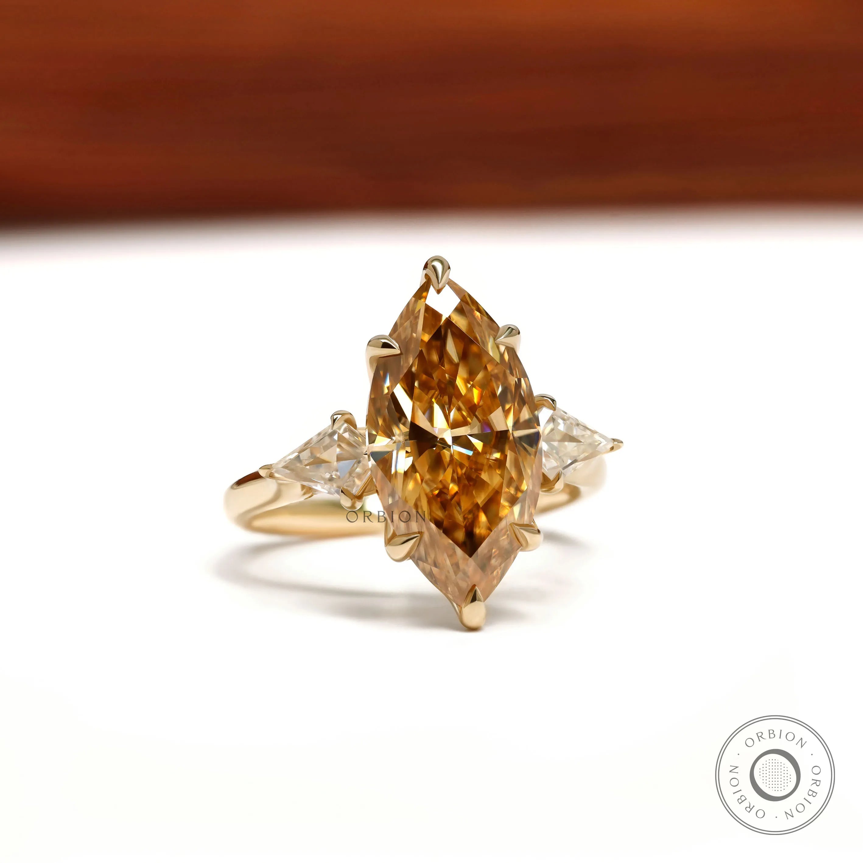 10k yellow gold cathedral ring featuring marquise champagne moissanite, tulip set, and accented bridge